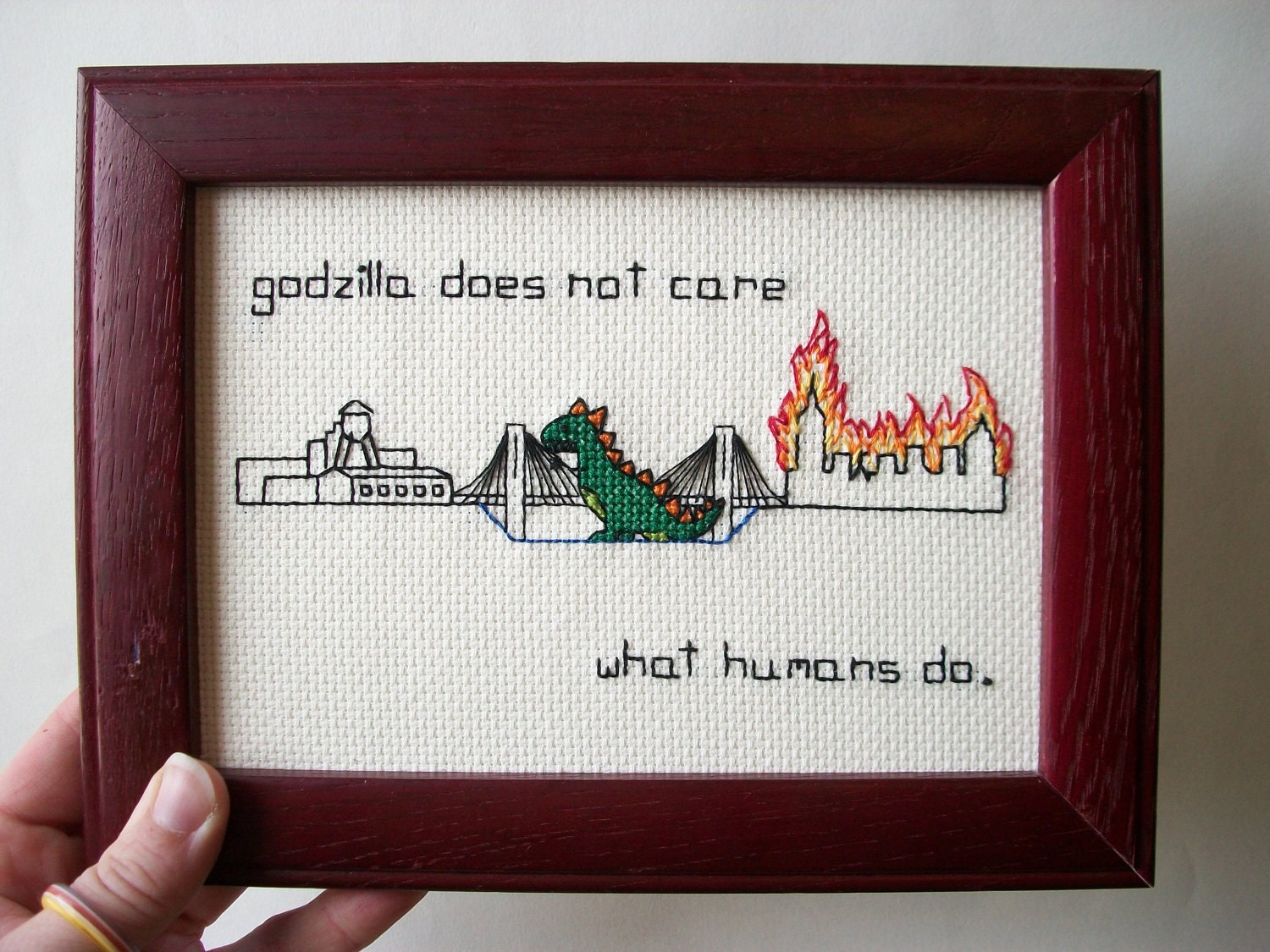 Godzilla burning down NYC -- and not even caring. Godzilla between Manhattan and Brooklyn, burning borough of your choice..