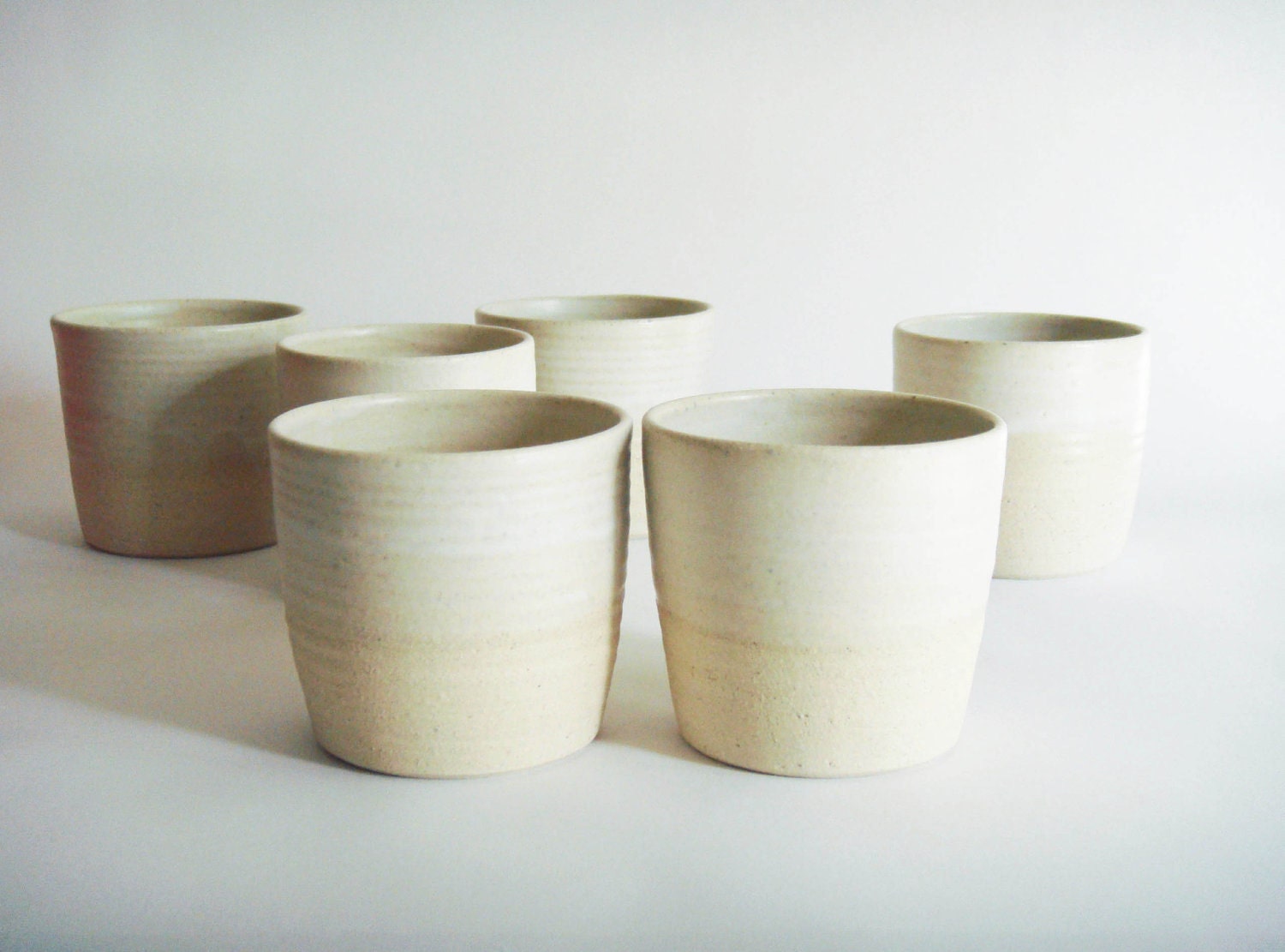 Two small white on white minimal ceramic cups