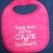 These fools put my CAPE on backwards on dark pink bib with all white writing