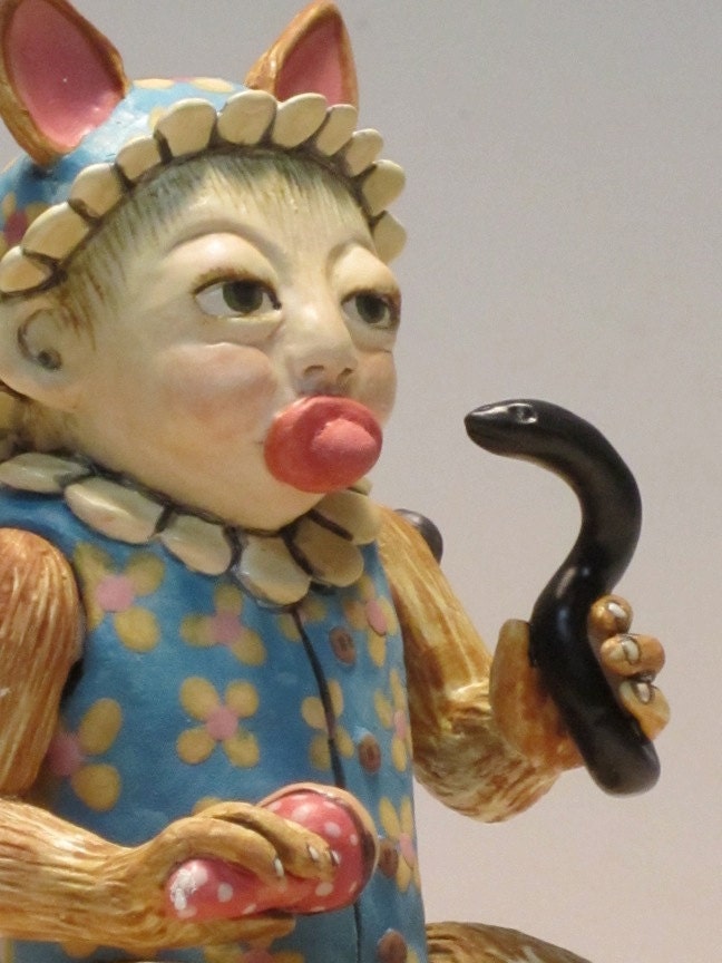 Ceramic doll holding rattler.