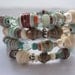 Wrap bangle bracelet made with paper beads accented with metal beads, glass and swaroski crystal beads