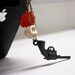 GUNS N' ROSES - Hanging Skull Red Rose and Black Revolver Chain iPhone Headphone Plug/ Dust Plug - Cellphone Accessories
