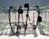 Black chain bracelet adorned with black shells and bicone beads, worn as necklace as well