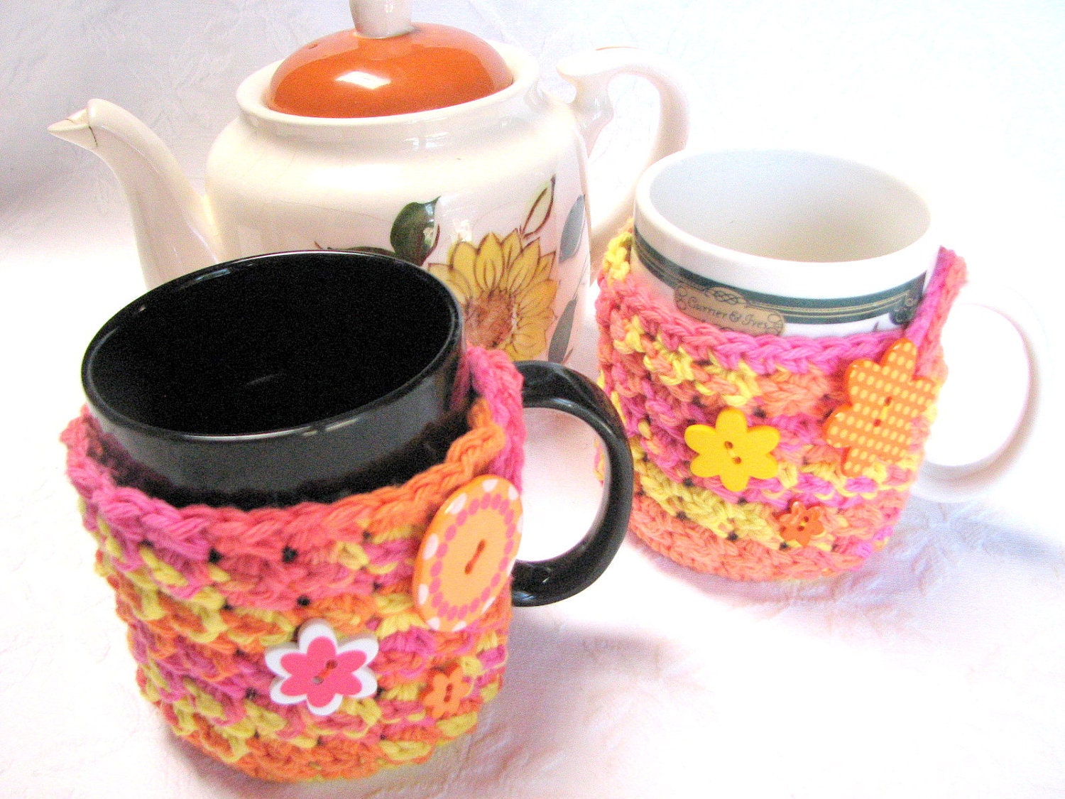 Matching pair of Bright Yellow/Orange Mug Hug cozies with coaster bottom, crocheted in 100% cotton, decorative buttons