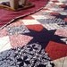 Queen size Sawtooth Star quilt in rich red, black, and creams.