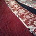 Queen size Sawtooth Star quilt in rich red, black, and creams.