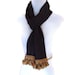 Long grey scarf with light gold tassel fringe.