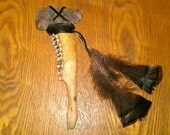 Primitive artifact Tomahawk with deer bone handle and turkey feathers.