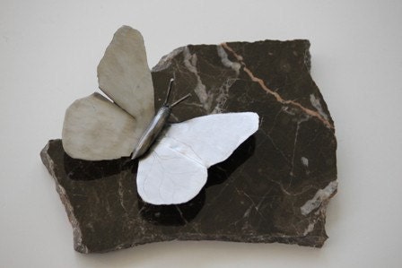 Silver butterfly on black marble tile