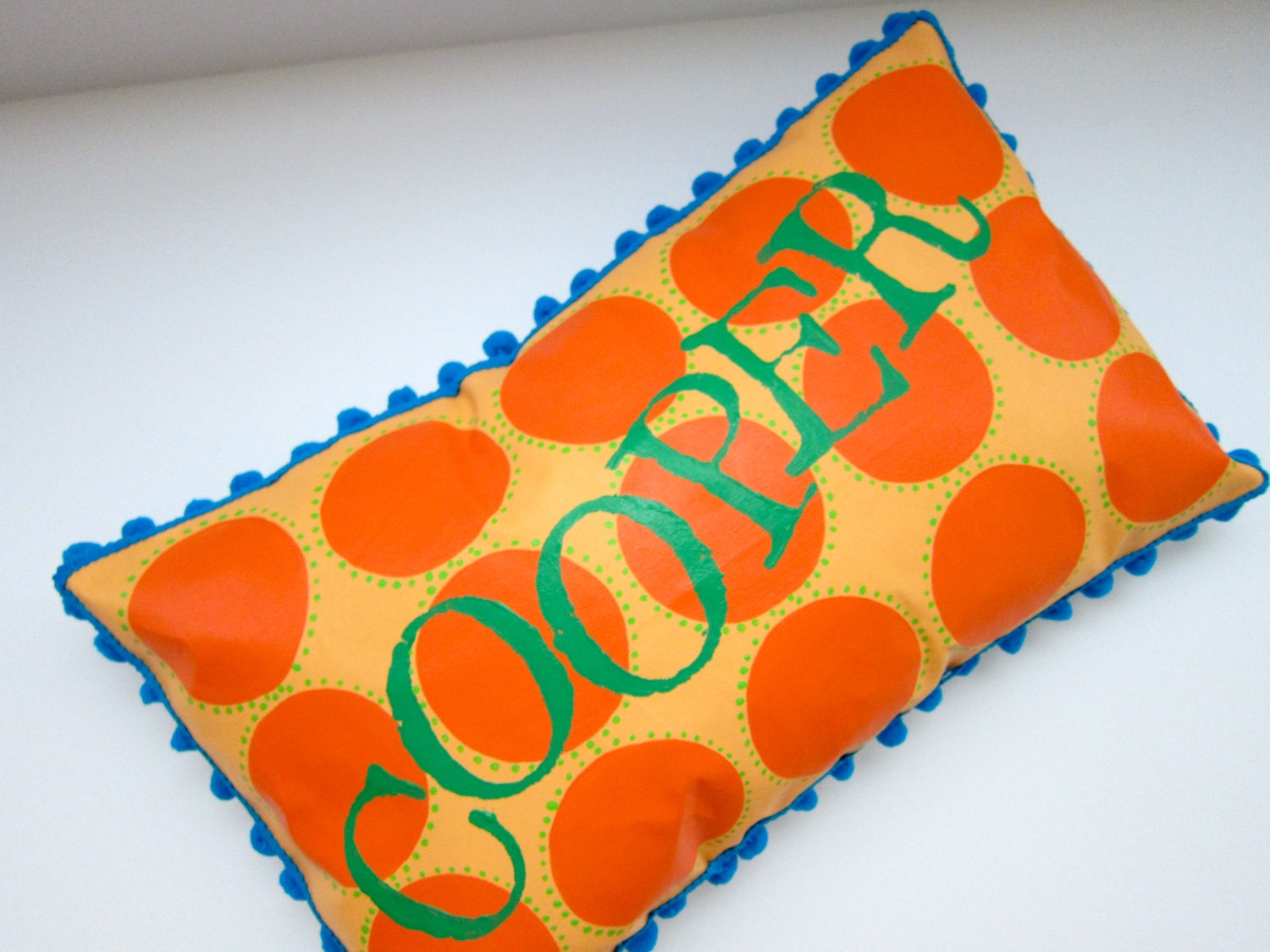 Baby pillow in orange and bright green. Personalized with name.