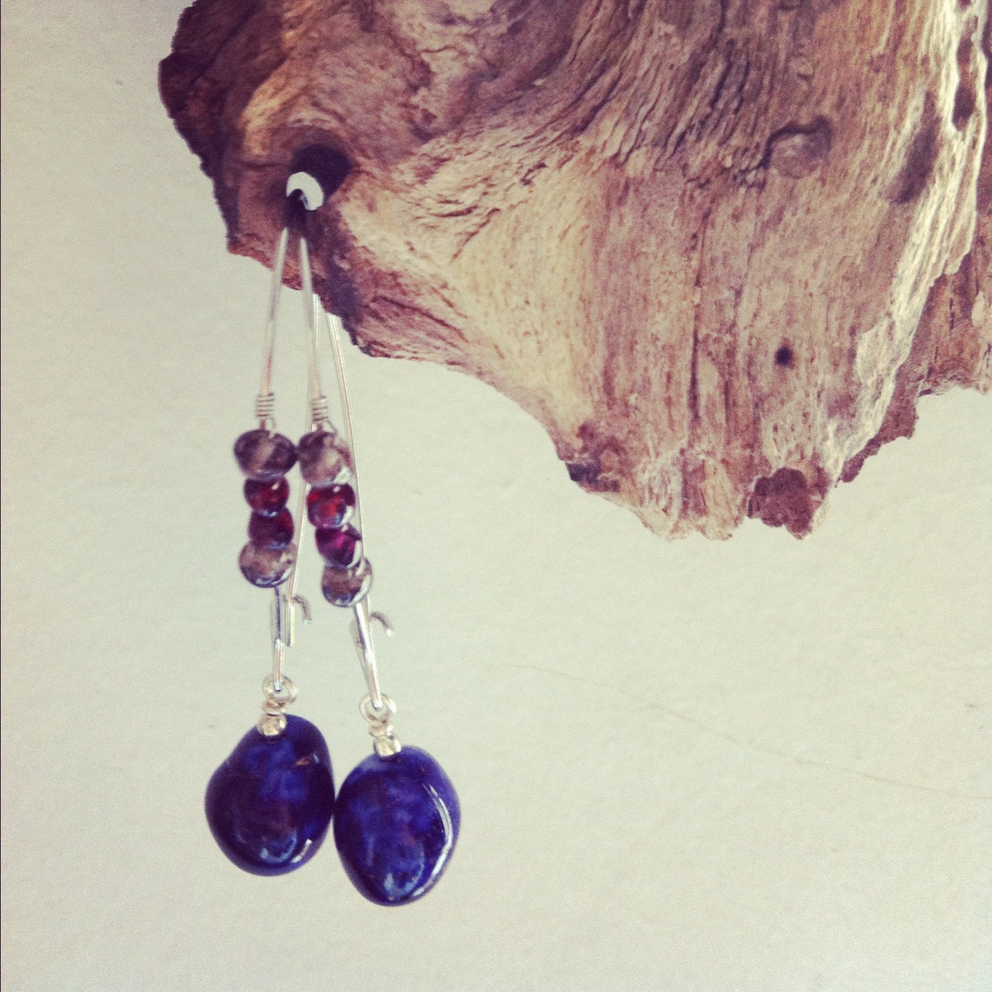 wire wrapped with garnet and smoky quartz with a dangling   blue glass  bead.