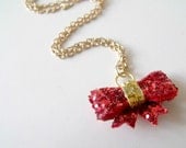 tiny red and gold glitter bow on gold-plated chain