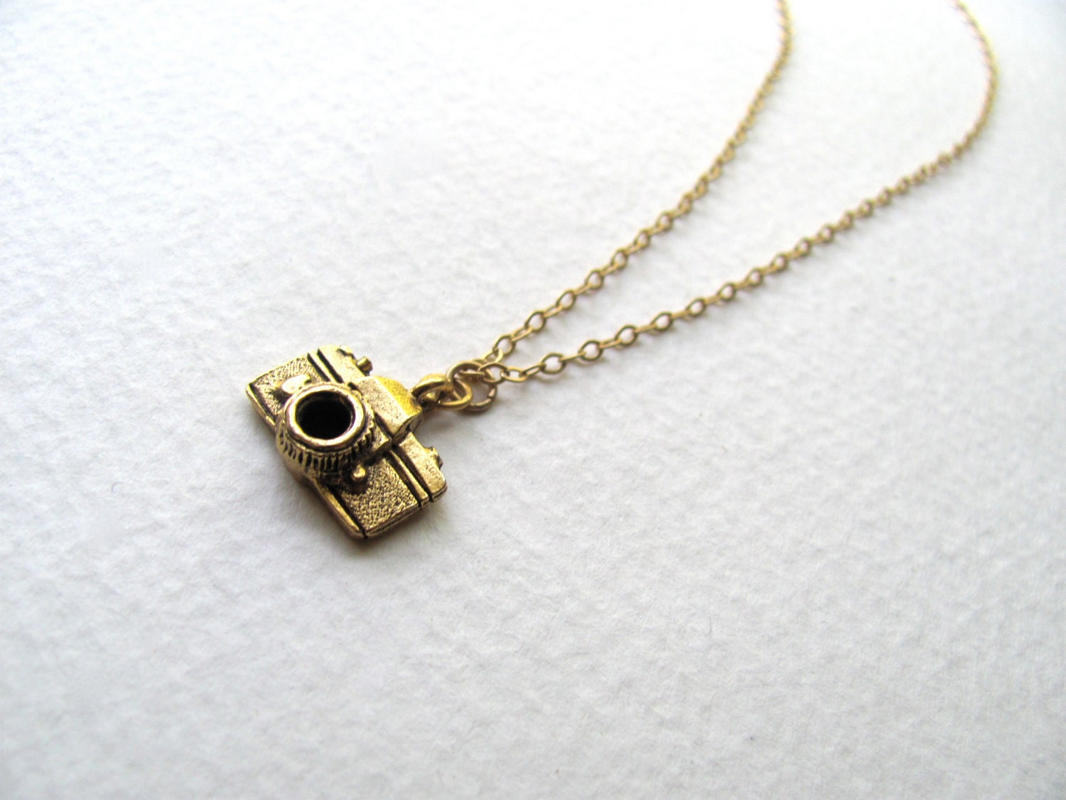 Gold camera charm necklace on delicate 14k gold plate chain, satin finish