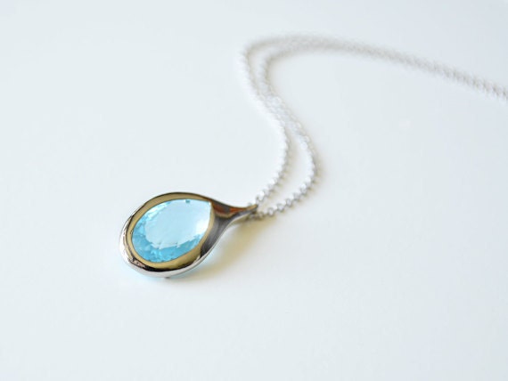 Aqua blue glass framed pendant necklace.