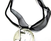 Music necklace, sheet music and silver music note charm on black ribbon.