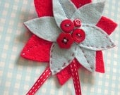 Red and blue felt flower corsage with button decoration and ribbon trim