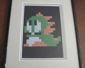 Bubblum (Bub) from Bubble Bobble 8 Bit NES cross stitch Framed