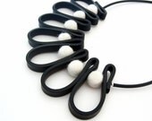 modern rubber necklace, contemporary design, urban jewelry, geometric fashion, monochrome, black and white, bib necklace