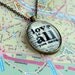 Bronze pendant necklace Love is All You Need Beatles lyrics on book page