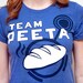 Women's Hunger Games Team Peeta T-Shirt with Bread Graphic, Blue, SIZE SMALL