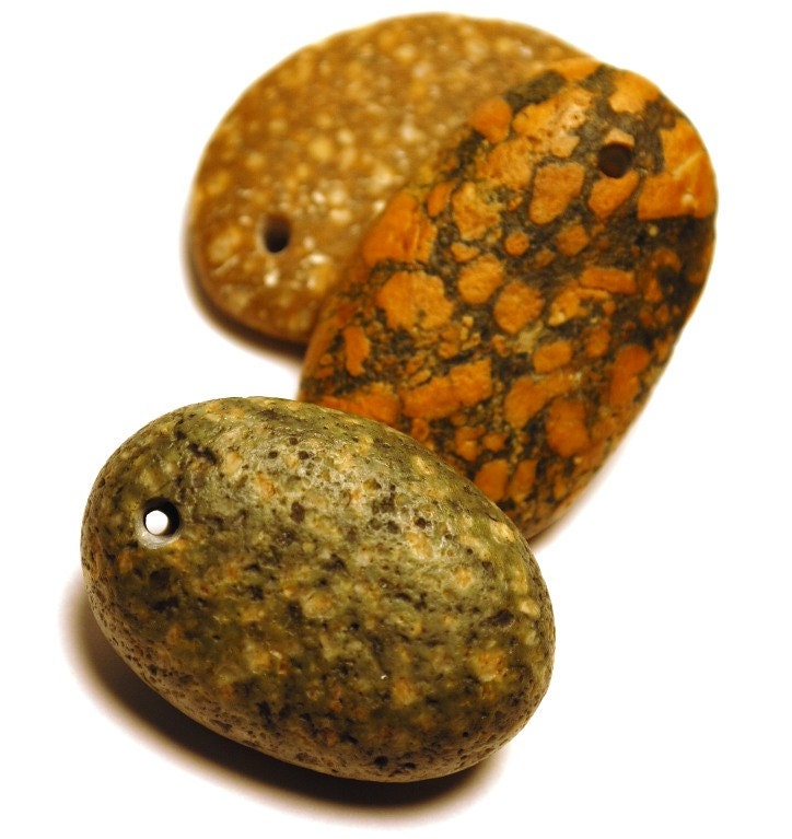 three mottled stones, drilled beach rocks with inclusions