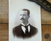 Antique photo of dashing man with mustache and intense stare