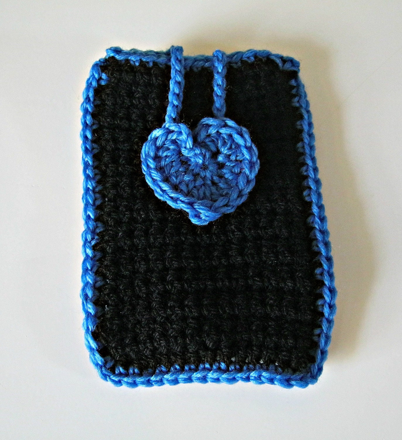 Crocheted phone cover in black with a mid blue heart and trim