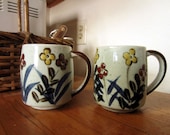 Two (2) vintage 1970s speckled stoneware floral mugs
