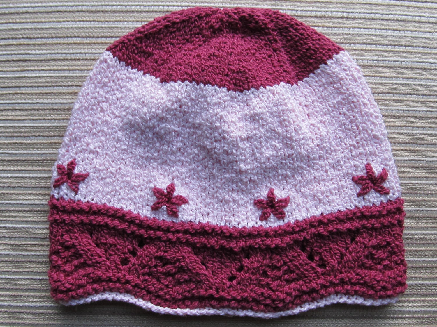 Number 65 Knitting Pattern Burgundy Hat with Fir Cone Stitch Border and Embroidered Daisies 0-4, 24 months/child