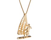 14k Gold plated silver necklace with a man who's surfing on a wind surfboard.