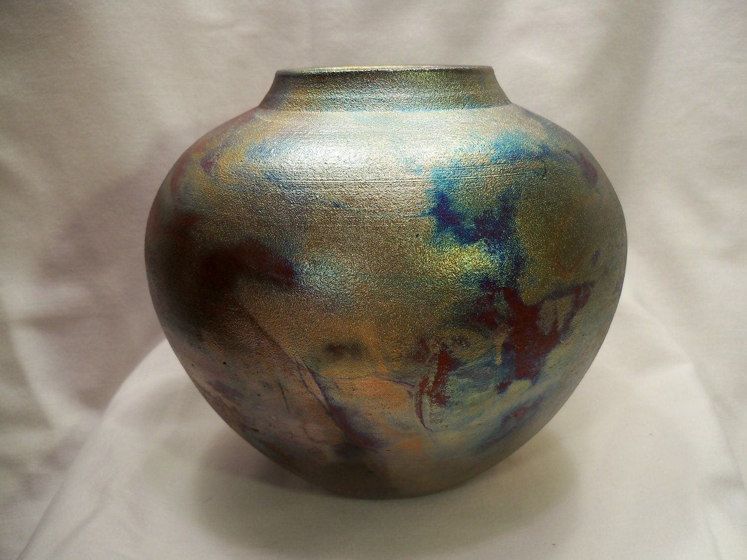 Beautiful handmade ceramic raku vase, with bright metallic colors