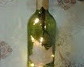 gold leaves lighted wine bottle with poinsettia flower pen topper. Hand decorated