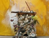 Round Bird Feeder Made From Recycled Pipe Covered in  Rocks and Twigs