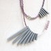 double geometric necklace with grey sticks and purple beads