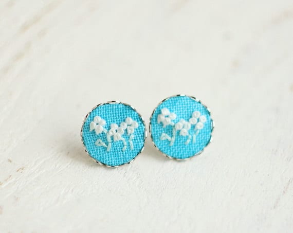 Teal blue stud earrings with floral ornament