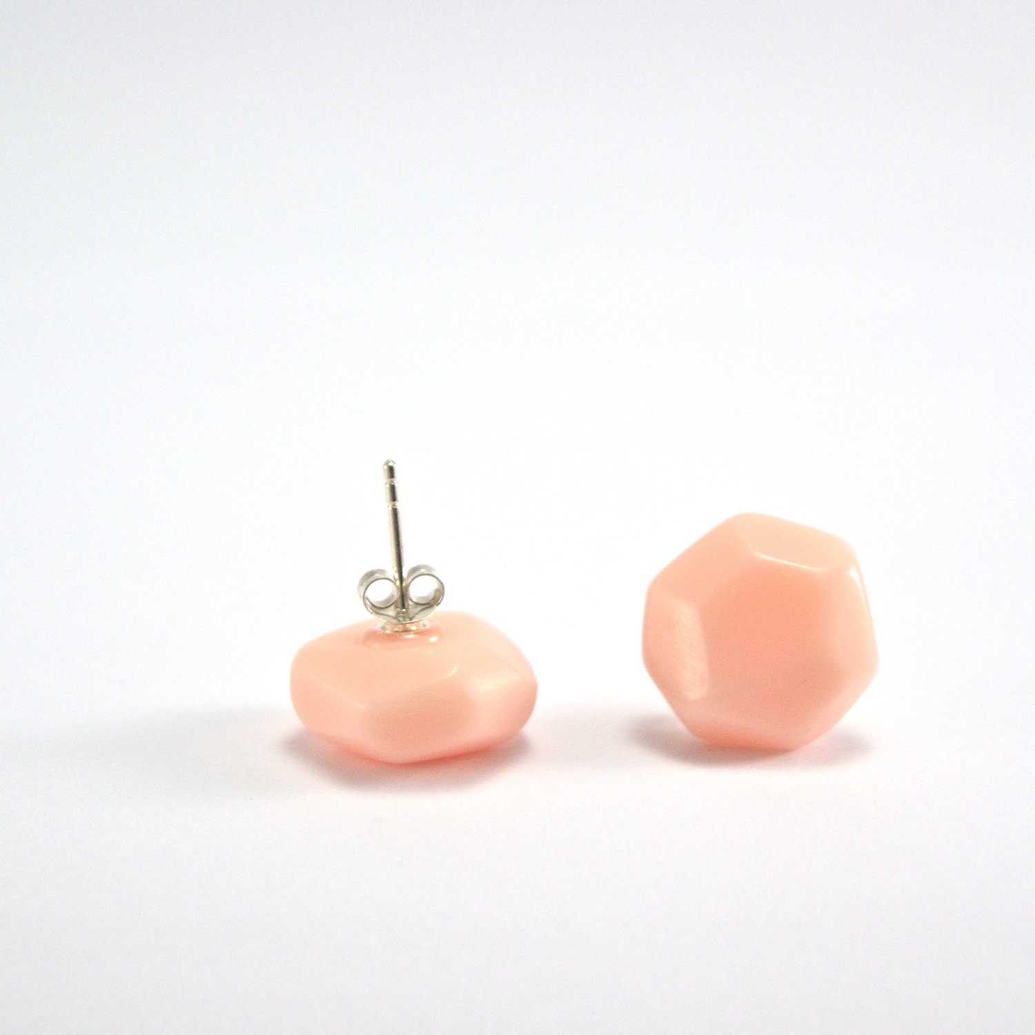 resin earrings in blush. orange facet geo posts, opaque peach resin studs, flat shape