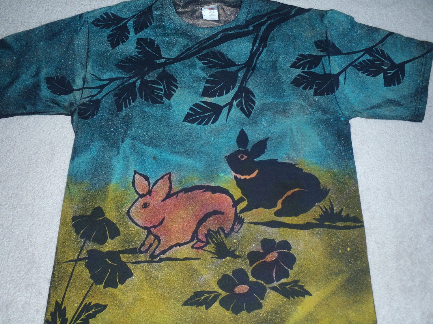 Two rabbits playing in the flower garden, man's large discharge t-shirt, then dyed with turquoise yellow green and soft orange.