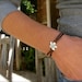 Sterling Spiral Fleur on Leather bracelet
