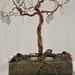 Tree assemblage with various wires on two vintage books with found objects.