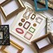 FRAMED EMBROIDERY ART - Wall art of a collection of gold, bronze and multicolored embroidered frames in a frame