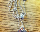Hand stamped "love is all you need" aluminum and copper necklace with antique silver love charm