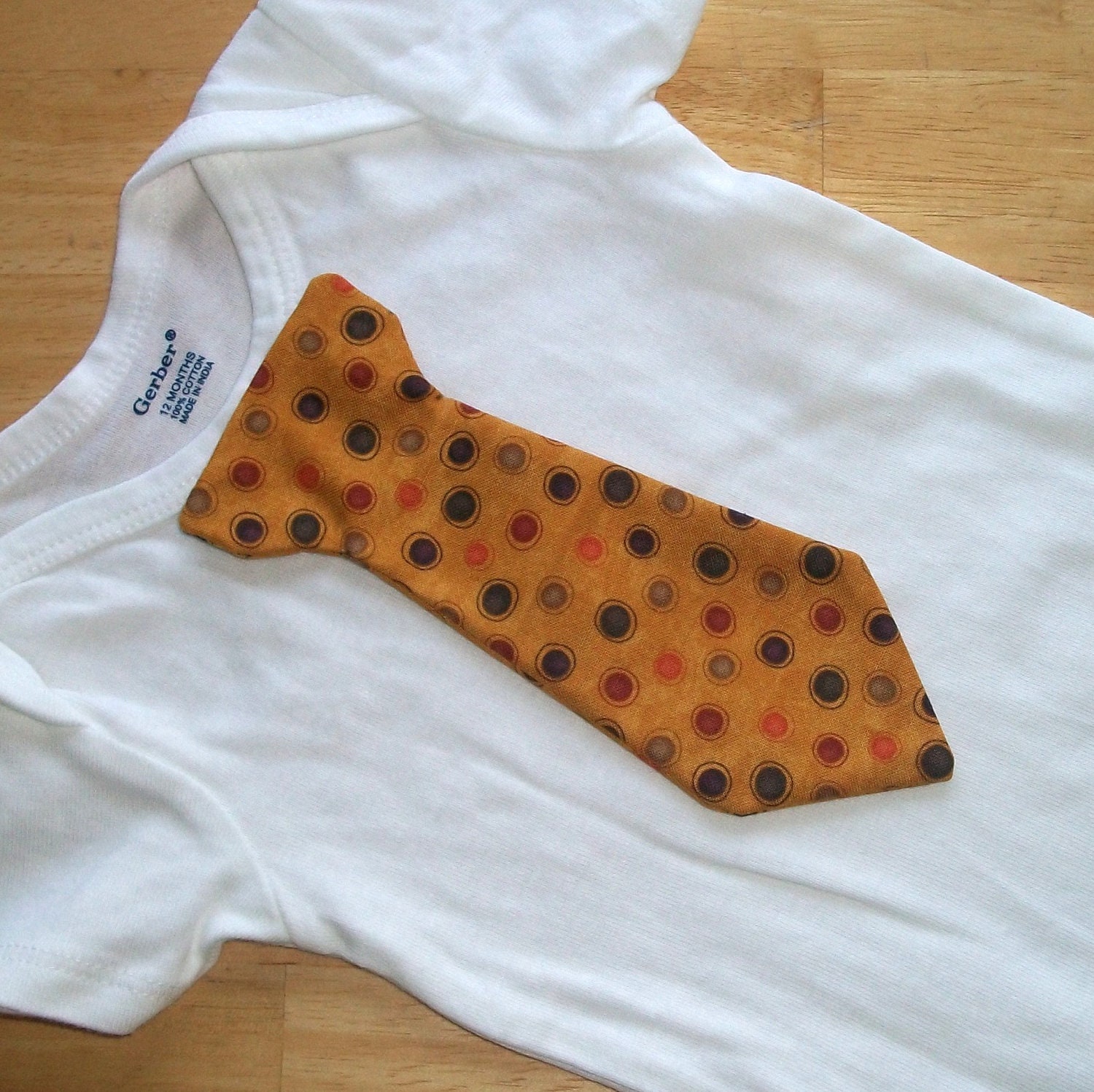 Baby onesie with orange, brown, tan and red dot tie. Perfect for Thanksgiving and hunting season.