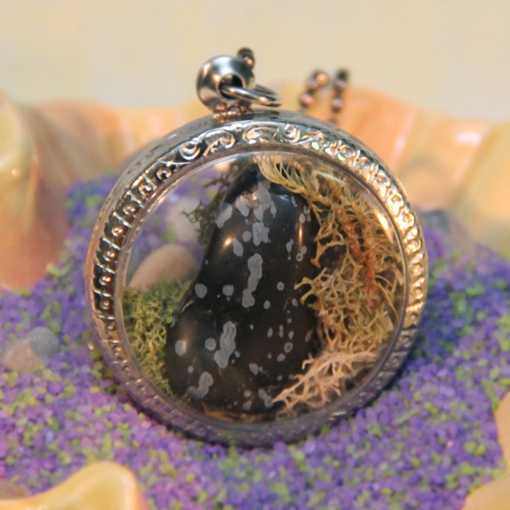 Miniature terrarium window locket. Large, round windows show piece of black snow flake obsidian stone with moss. Medium length