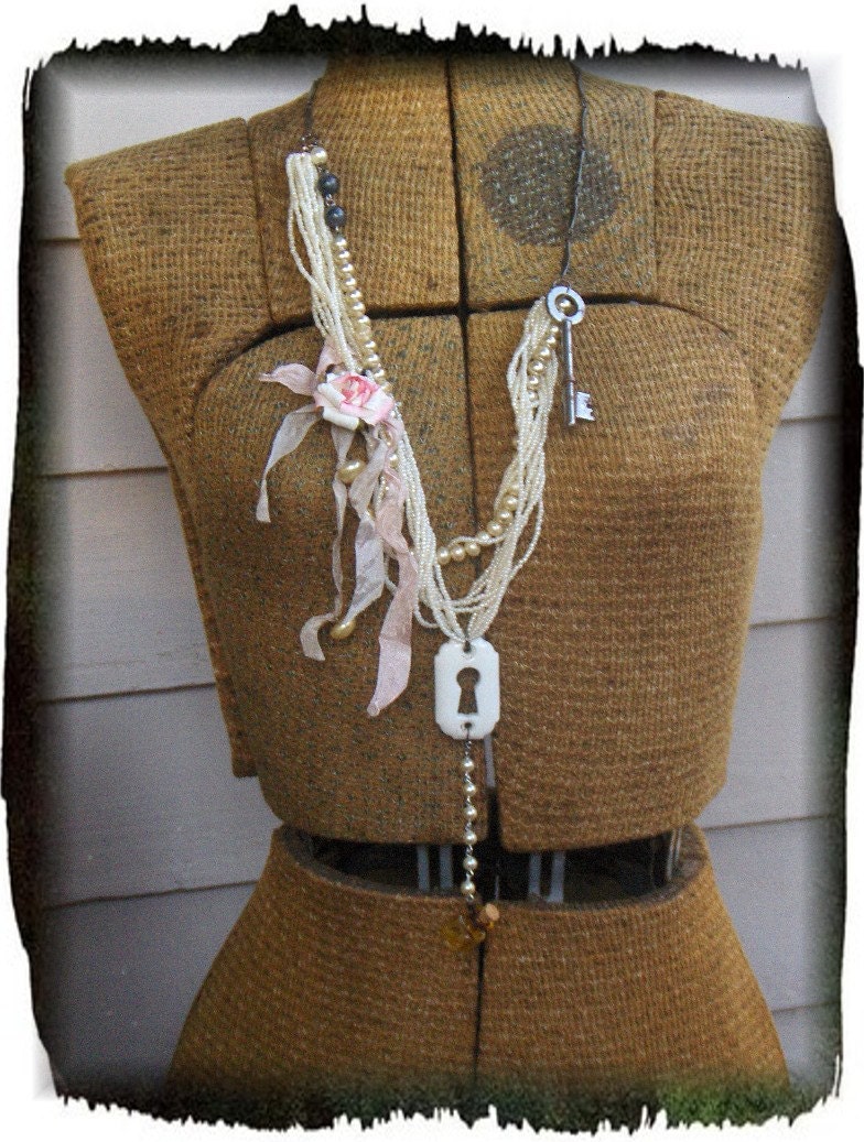 Flowers in the attic. Upcycled faux pearls, antique key and escutcheon, millinary rose, tiny glass bottle and baubles statement necklace