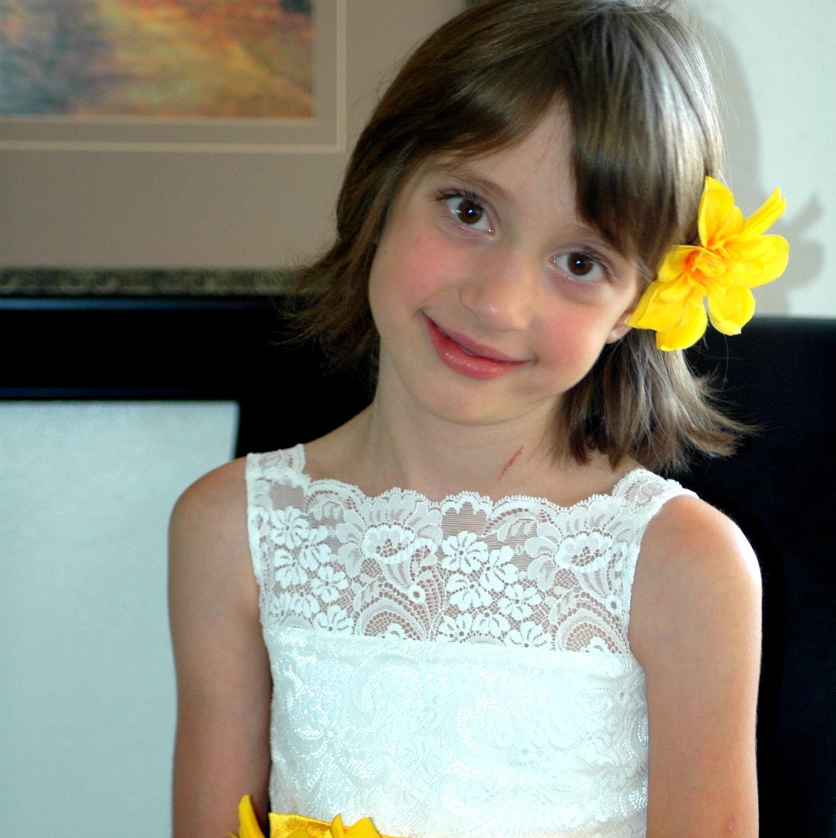 Ivory  flower girls dress with a tulle skirt flower sash and petals in the skirt.  A white or ivory dress for a wedding with a lace bodice