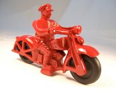 Toy motorcycle vintage 1930s reproduction cop on red cycle with black rubber wheels. Made in the USA.