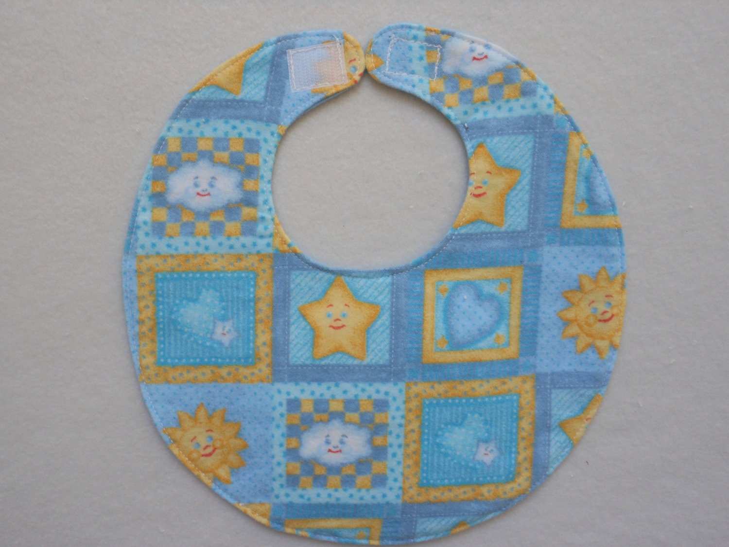 Baby bib, four thick soft layers, reversible,blue with happy yellow suns and stars
