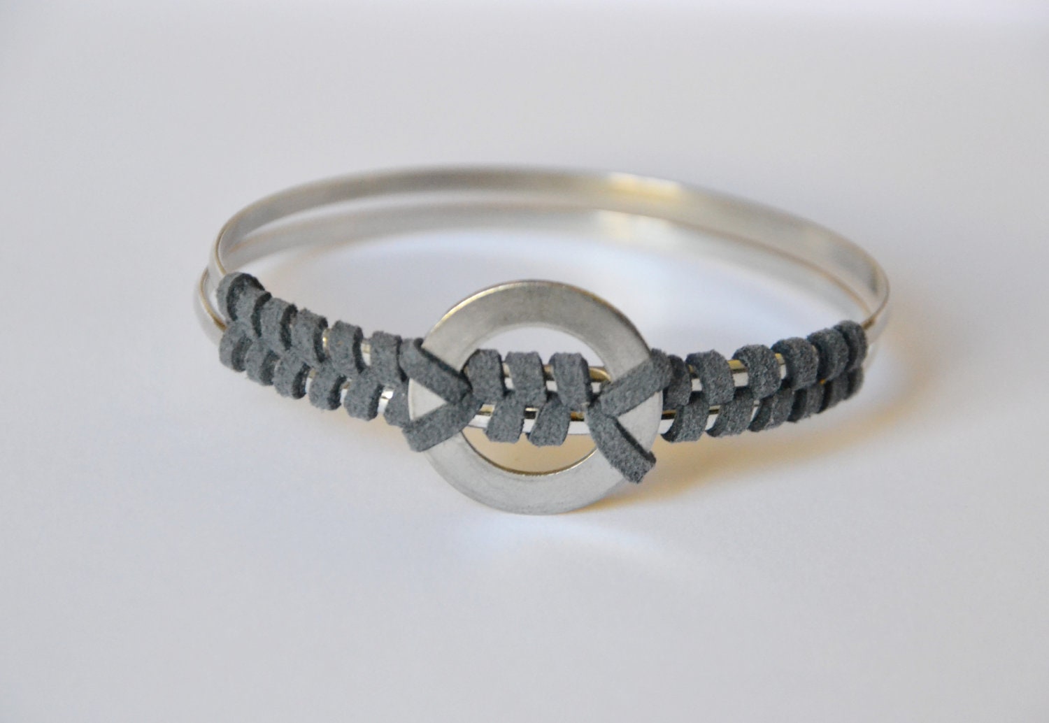 Gray suede bangle. Suede hand wrapped around two silver bangles with vintage nuts & bolts tribal piece