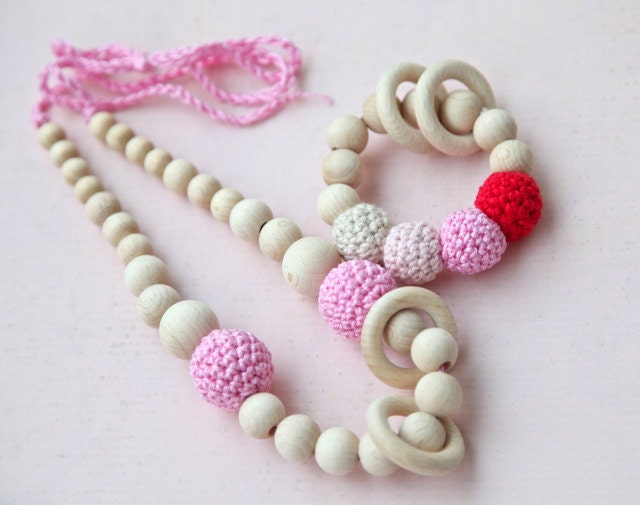 Set of 2. Pink nursing rings necklace and pink, red and beige teething ring toy.