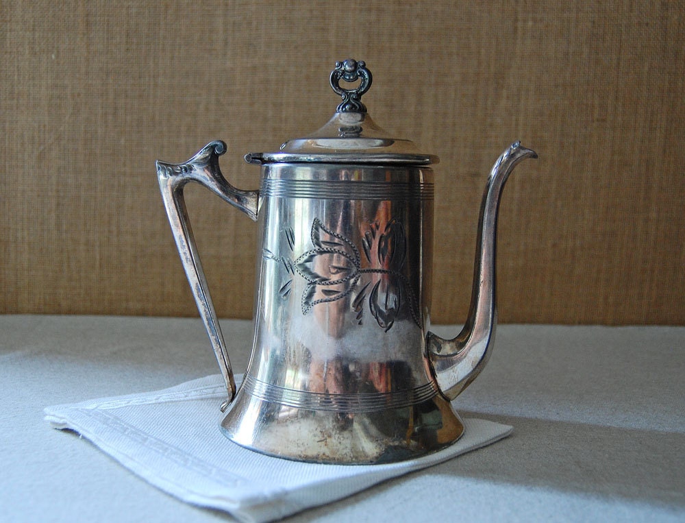 vintage silver tea pot with engraved floral motif